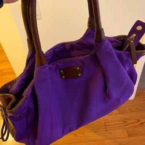 Purple Kate spade purse with brown leather and gold detailing.